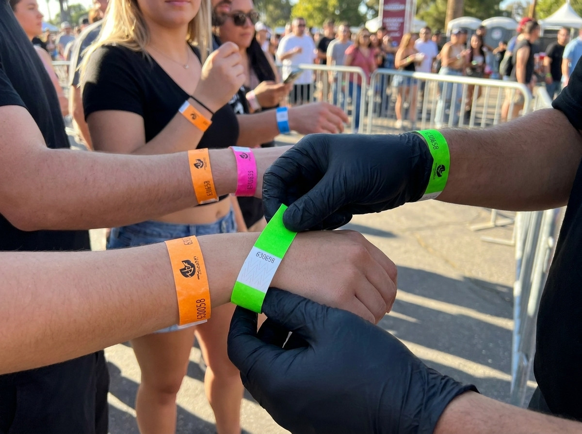 Seguranca verificando pulseiras coloridas no ponto de acesso do evento