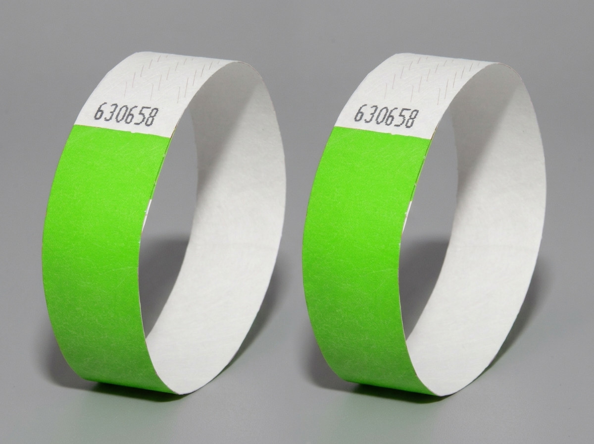 Comparação lado a lado de uma pulseira Tyvek e de uma pulseira de vinil PVC com impressão de alta definição do mesmo logotipo de festival